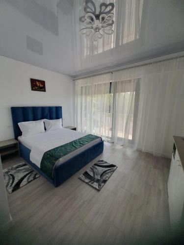 a bedroom with a bed and a large window at Constantin Rooms in Eforie Nord