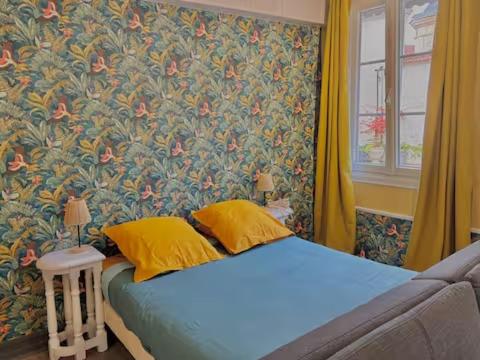 a bed with two yellow pillows in a bedroom at LA MONGEARDIERE in Ay