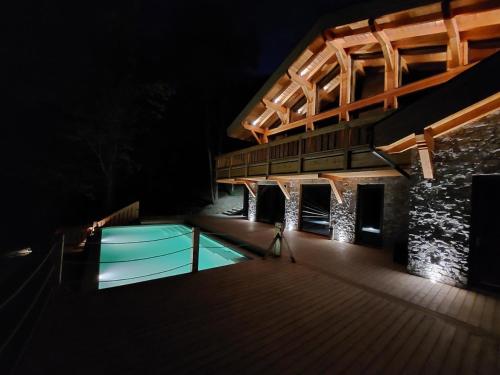 a lit up deck with a swimming pool at night at A Páholy - Grand Chalet Mátra in Mátraszentimre