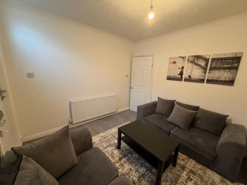 a living room with a couch and a table at Central Luton, Guest House, Contractor Friendly, Long Stays Welcome in Luton