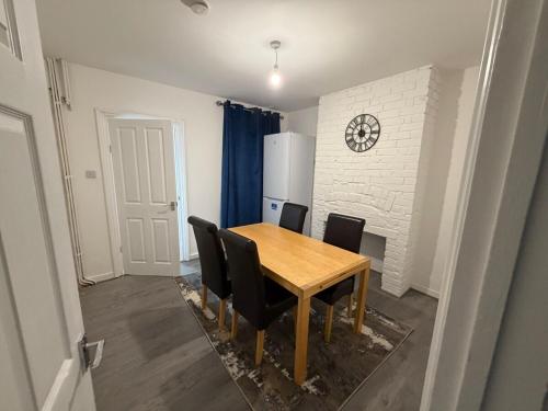 a dining room with a wooden table and black chairs at Central Luton, Guest House, Contractor Friendly, Long Stays Welcome in Luton