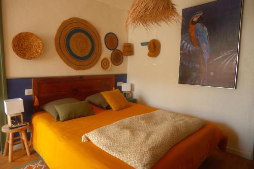 una camera da letto con un letto e alcuni cappelli sul muro di La Norélie a Saint-Sulpice-de-Royan
