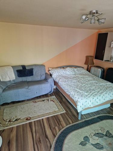 a bedroom with a bed and a couch and rugs at Casa LarisaAndrei in Bîrsău