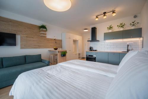 a bedroom with a large white bed and a couch at Apartmán Sekvoja in Nová Baňa