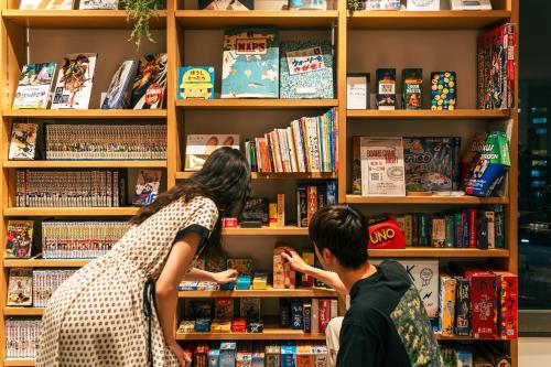 a man and a woman looking at books in a bookstore at Richmond Hotel Premier Tokyo Schole in Tokyo