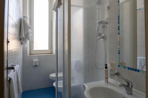 a bathroom with a shower and a sink and a toilet at Hotel Centrale in Pineto