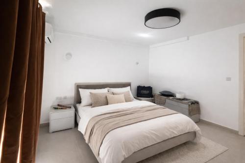 a bedroom with a large bed with white walls at Ta' Cenc Residence Block C, Apt 4 in Sannat