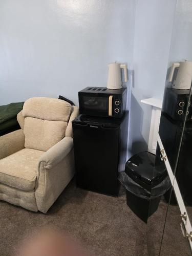 a living room with a couch and a microwave at Room near Oxford city centre in Oxford