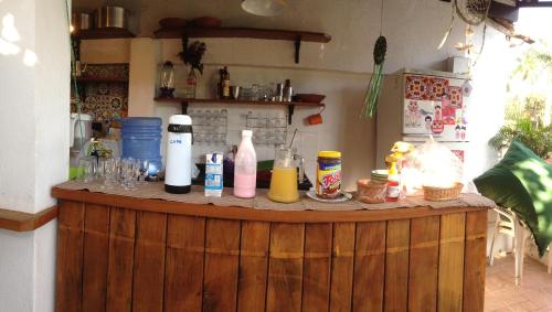 eine hölzerne Bar mit Flaschen und Gläsern darauf in der Unterkunft Maracujá Hostel in Paraty