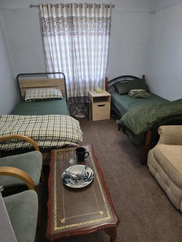 a room with two beds and a table with a plate on it at Room near Oxford city centre in Oxford