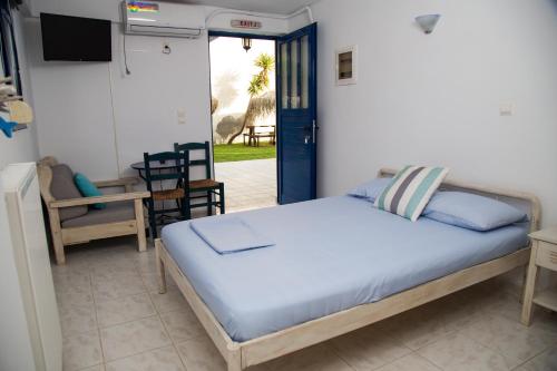 a bedroom with a bed and a door to a patio at Ξενώνες Ανεμόμυλοι - Windmills Hotel in Panayía