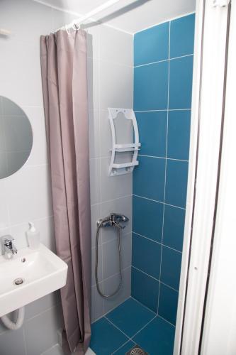 a bathroom with a shower and a sink at Ξενώνες Ανεμόμυλοι - Windmills Hotel in Panayía