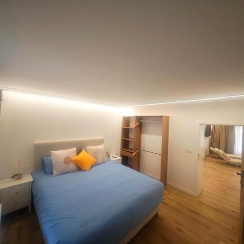 a bedroom with a bed with blue sheets and yellow pillows at Le onze in Namur