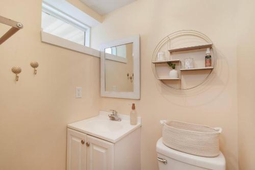 a bathroom with a sink and a mirror and a toilet at Chic Groton Studio • A Cozy, Modern & Central Gem in Groton