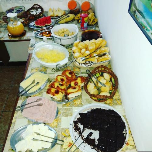 een tafel met veel verschillende soorten voedsel bij Pousada Arco Íris in Abraão