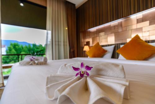 a hotel room with a bed with a flower on it at Burapa Boutique in Chiang Mai