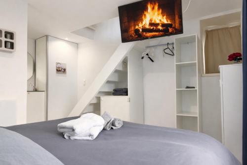 a room with a bed with a fireplace and a tv at Le Talantueux in Talant