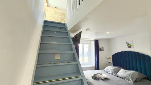 a bedroom with a blue staircase next to a bed at Le Talantueux in Talant