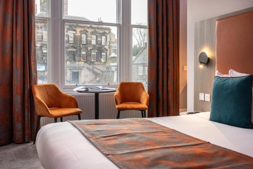 a hotel room with a bed and two chairs and a window at Linen Bank Residence - Aparthotel in Linlithgow