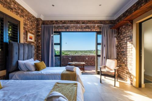 a bedroom with two beds and a large window at Seemeeu, Gouritsmond in Gouritzmond