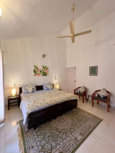 a bedroom with a bed and a ceiling fan at Green Castle in Gonikoppal