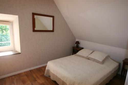 a bedroom with a bed and a window at Gite de la Mare de la Trémaillerie in Blainville-sur-Mer