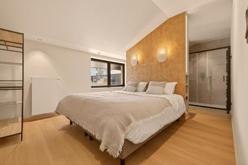 a bedroom with a large bed and a large window at Lakeside Lodges - Gîte 6 personnes à 10 min circuit Spa Francorchamps in Jalhay
