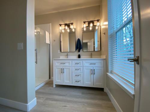 a bathroom with a white sink and two mirrors at Historic Main Street Hotel in Pleasant Grove