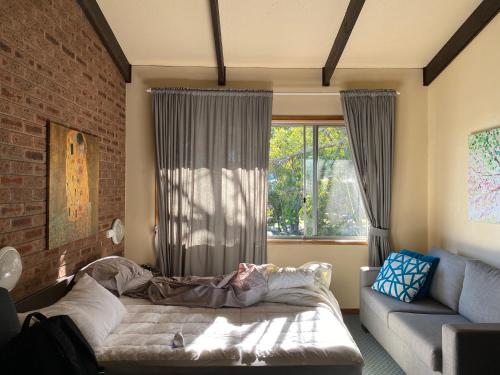 a bedroom with a bed in front of a window at Alpine Gables Apartment in Jindabyne