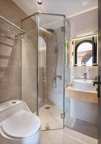 a bathroom with a shower and a toilet and a sink at Jan Casa in Ho Chi Minh City