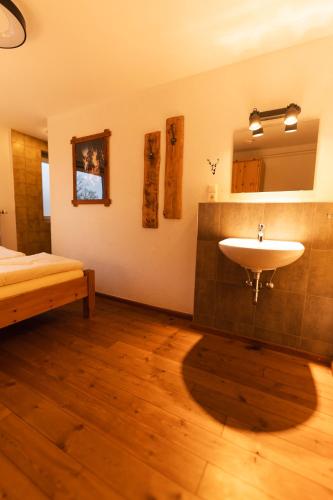 a bathroom with a sink and a bed at Bullhead House in Warmensteinach