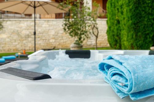 a jacuzzi tub with a blue towel in it at Villa Vernier by IstriaLux in Kringa