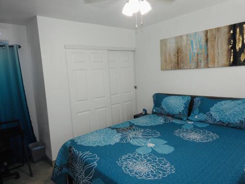 a bedroom with a bed with a blue comforter at AWESOME PLACe in Las Vegas
