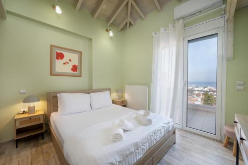 a bedroom with a bed and a large window at Panorama City Loft in Mytilene