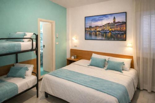 ein Schlafzimmer mit zwei Betten und einem Gemälde an der Wand in der Unterkunft Hotel Jasmine Beach in Rimini