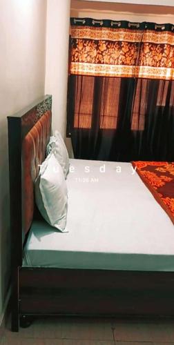 a bed sitting in a room with a curtain at SGroom in Amritsar