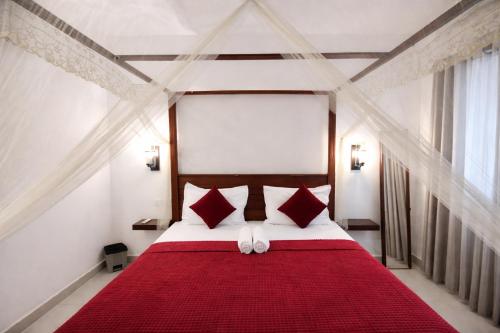 a bedroom with a large red bed with red pillows at W Hotel Mount Lavinia - Colombo in Colombo
