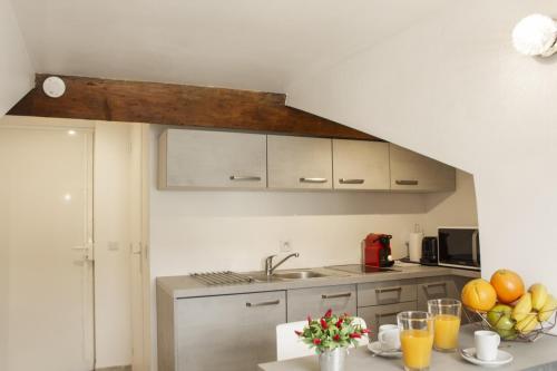 una cucina con un lavandino e un tavolo con la frutta di Antibes Bis a Cannes