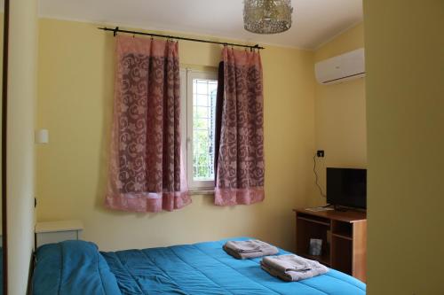 a bedroom with a blue bed and a window at Agrimar 2 in Rignano Flaminio