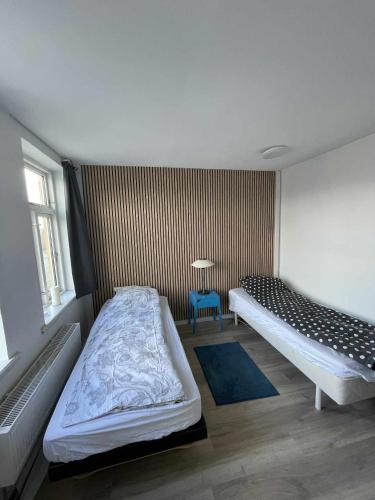 a bedroom with two beds and a blue chair at Villa Katry in Augustenborg