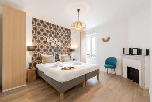 a bedroom with a large bed and a blue chair at Totolulu Cannes Luxury Properties in Cannes