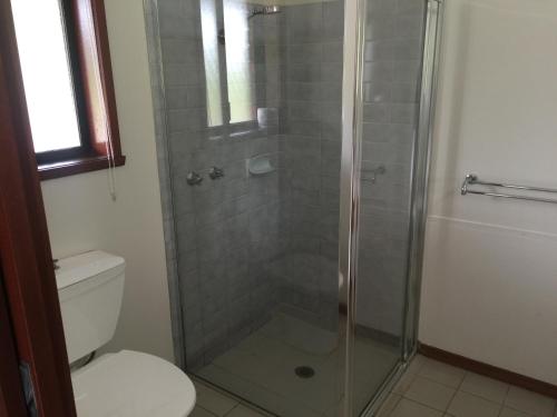 a bathroom with a glass shower with a toilet at Warragul Views Motor Inn in Warragul