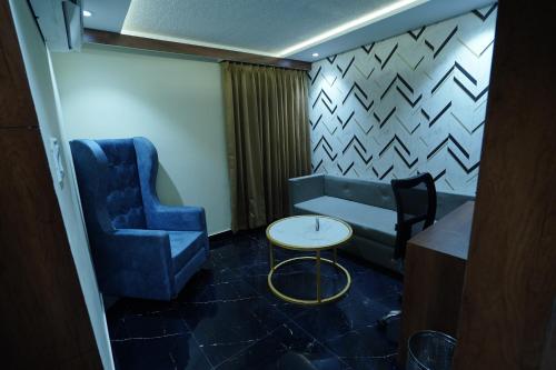 a waiting room with a blue chair and a table at hotel shree palace in Ratlām