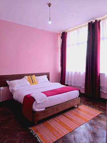 a bedroom with a large bed with red curtains at Triple SSS Hotel in Nairobi