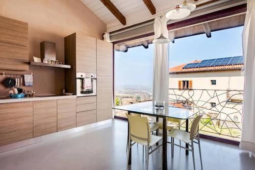 a kitchen with a table and chairs and a large window at Agriturismo CasaMatilda in Dogliani
