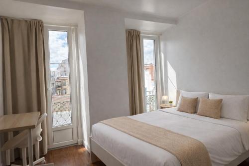 a bedroom with a bed and a large window at Aurea Stay Lisbon-Quarto privado no centro in Lisbon