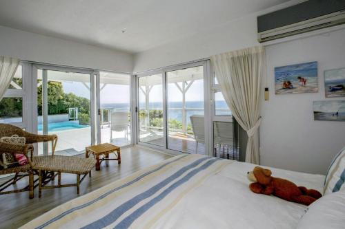 a bedroom with a bed with a teddy bear on it at The Seaside View in Simonʼs Town