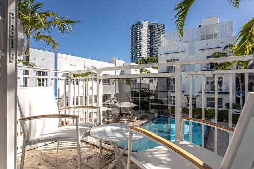 a balcony with chairs and a swimming pool on a building at Pestana South Beach Miami in Miami Beach