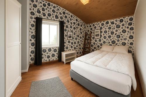 a bedroom with a white bed and floral wallpaper at Guesthouse in Hellosan in Vestvågøya