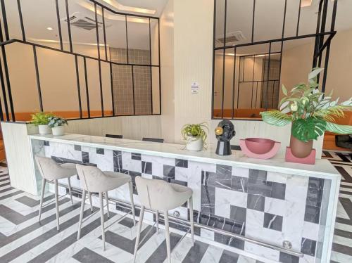 a lobby with a bar with white stools at Amazing High Floor Luxury Studio in Sathani Ban Hua Mak
